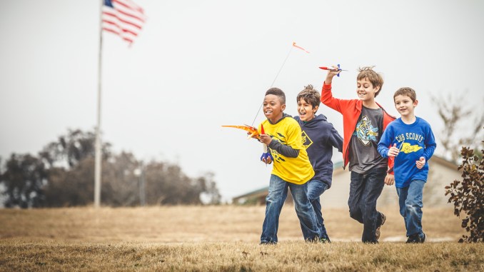 Cub Scouts running with rockets